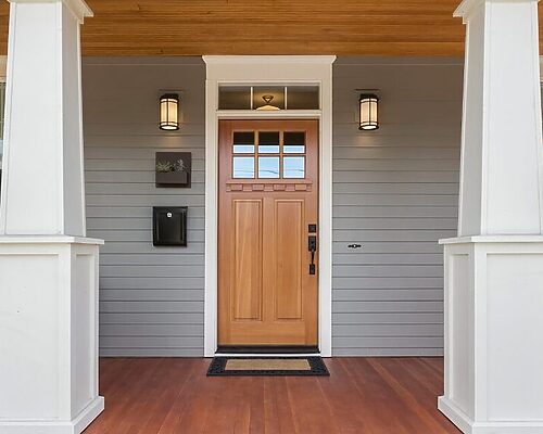 wooden door with grey siding and front porch